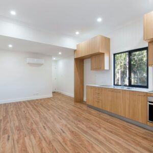 A kitchen with wooden floors and white walls.