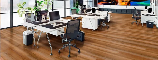 A group of desks with chairs and laptops on top.