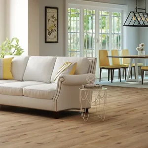 A living room with white furniture and wood floors.
