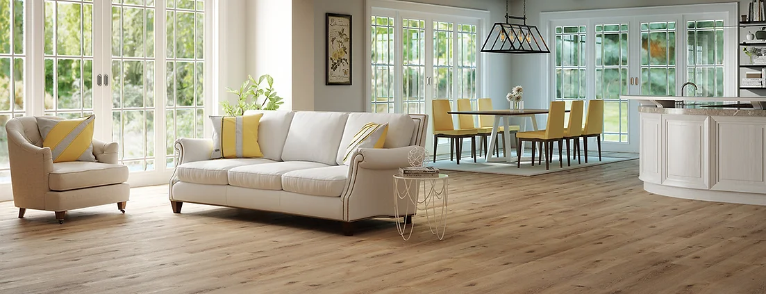 A living room with white furniture and wood floors.